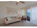 Bright living room featuring a sofa, side chair, ceiling fan, and access to the outdoor balcony with ocean views at 301 N Waccamaw Dr. # 209, Garden City Beach, SC 29576