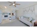 Living room space featuring a sofa, a display case and a partial view of the kitchen with white appliances and soft decor at 301 N Waccamaw Dr. # 209, Garden City Beach, SC 29576