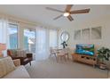 Open concept living room featuring a ceiling fan, dining table, television and comfortable seating with access to an outdoor balcony at 301 N Waccamaw Dr. # 209, Garden City Beach, SC 29576