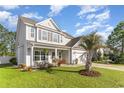 Well-maintained home with a lush front lawn, palm tree, and inviting front porch with rocking chairs at 3129 Bramble Glen Dr., Myrtle Beach, SC 29579
