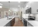 Modern kitchen features stainless steel appliances, white cabinets, and a breakfast bar overlooking the dining area at 3325 Hughes Gasque Rd., Aynor, SC 29511