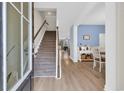 Inviting foyer with staircase, light wood floors, and views into the adjacent dining area at 4251 Pecan St., Little River, SC 29566