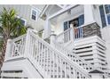 Close up of front entrance showing porch with decorative wreath, stone accents, and stairway at 5368 Ocean Village Dr., Myrtle Beach, SC 29577