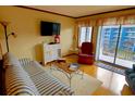 Inviting living room with a striped sofa, a comfortable chair, and a balcony with a view at 5905 S Kings Highway # 432-A, Myrtle Beach, SC 29575