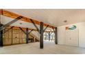 Spacious ground-level area with wooden beams, stairs to the upper level, and access to an outdoor shower at 6001 - 1527 S Kings Hwy., Myrtle Beach, SC 29575