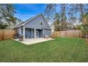 Expansive backyard featuring a patio area with outdoor seating, lush green lawn, and privacy fencing at 624 Blackberry Ave., Murrells Inlet, SC 29576