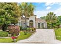 Beautiful home exterior showcasing lush landscaping, a brick driveway, and an inviting entrance at 7584 Regina Ct., Myrtle Beach, SC 29572