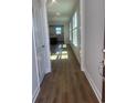 Bright hallway featuring gleaming hardwood floors, multiple windows, and access to the kitchen at 1226 Crested Iris Way, North Myrtle Beach, SC 29582