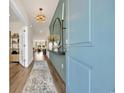 Elegant foyer with wood floors, designer lighting, and a stylish accent wall with a large mirror at 123 Tbd Joyce Dr, Longs, SC 29568