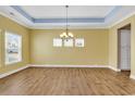 Bright dining room showcasing a tray ceiling, gleaming floors, and ample natural light from multiple windows at 141 Southgate Ct., Pawleys Island, SC 29585