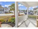 Inviting front porch showcasing white columns, a charming railing, and colorful landscaping at 141 Southgate Ct., Pawleys Island, SC 29585