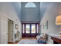 Grand foyer with high ceilings, beautiful wood floors, and an elegant rug that leads to the front door at 2425 South Bay St., Georgetown, SC 29440