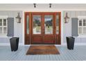 Inviting entryway featuring a wood door, decorative lanterns, and modern planters for added curb appeal at 2425 South Bay St., Georgetown, SC 29440