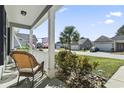 Relaxing front porch view with rocking chair and lush landscaping at 334 Marino Trail, Longs, SC 29568