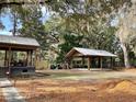 Large backyard featuring a covered deck, additional covered structure, and ample green space at 3633 Kings River Rd., Pawleys Island, SC 29585