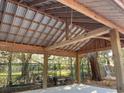 Interior view of the wooden frame of the back yard pavilion featuring metal roof and concrete base at 3633 Kings River Rd., Pawleys Island, SC 29585