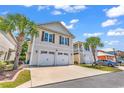 Spacious two-car garage and a charming exterior design complemented by mature palm trees at 382 Lumbee Circle, Pawleys Island, SC 29585