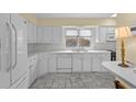 Bright kitchen featuring white cabinetry, tiled backsplash, and a window overlooking the outdoor space at 5616 N Kings Hwy., Myrtle Beach, SC 29577