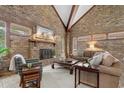 Spacious living room featuring a brick fireplace, vaulted ceilings with exposed beams, and comfortable seating at 5616 N Kings Hwy., Myrtle Beach, SC 29577