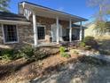 All-brick home featuring a covered porch with elegant white columns and manicured landscaping at 581 Vaux Hall Ave., Murrells Inlet, SC 29576