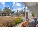 Relaxing front porch view showcasing outdoor seating, greenery, and a peaceful neighborhood street at 626 5Th Ave. S, Surfside Beach, SC 29575