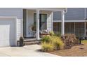 Inviting porch area with comfortable seating, potted plants, and a beautifully landscaped front yard at 626 5Th Ave. S, Surfside Beach, SC 29575