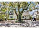 Charming home exterior features a well-manicured lawn, inviting porch, and mature trees, with golf cart at 1129 Palmetto St., Georgetown, SC 29440