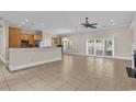 Open-concept living room with kitchen, tile floors, fireplace and plenty of natural light at 129 Waterfall Circle, Little River, SC 29566