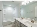 Bright bathroom featuring double sinks, a large mirror, and a tub with shower at 2504 Watershed Way, Longs, SC 29568