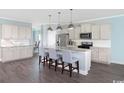 Modern kitchen with stainless steel appliances, a large island, and stylish pendant lighting at 2504 Watershed Way, Longs, SC 29568