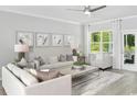 Inviting living room with large windows, neutral tones, stylish furniture, and a decorative ceiling fan at 2620 Watershed Way, Longs, SC 29568