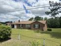 Traditional brick home featuring a well-kept lawn and mature landscaping, set against a partly cloudy sky at 3328 Rose Hill Rd., Georgetown, SC 29440