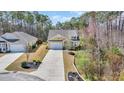 Aerial view of a yellow home with a long driveway and lush green landscaping at 343 Scottsdale Ct., Murrells Inlet, SC 29576