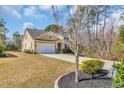 Yellow home with two-car garage, landscaped yard, and mature trees at 343 Scottsdale Ct., Murrells Inlet, SC 29576