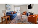 Comfortable living room with blue sofa, orange chair, area rug, and access to a balcony at 4201 N Ocean Blvd. # I3, North Myrtle Beach, SC 29582
