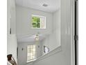 White staircase showcasing multiple windows for natural light, with a stylish light fixture at 4305 Lotus Ct. # G, Murrells Inlet, SC 29576