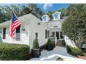 Close up of a well-maintained home, showcasing an American flag, dormer windows, and manicured landscaping at 50 Painted Bunting Ct., Pawleys Island, SC 29585