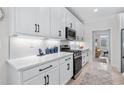 Modern kitchen featuring white cabinets, quartz countertops, stainless steel appliances, and a stylish backsplash at 870 Monterrosa Dr., Myrtle Beach, SC 29572