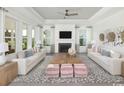 Bright living room featuring tray ceilings, a fireplace, and stylish contemporary decor at 9505 Long Meadow Way, Longs, SC 29568