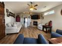 Bright living room featuring hardwood floors, a brick fireplace, a ceiling fan and comfortable seating at 9883 Conifer Ln., Murrells Inlet, SC 29576