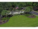 Welcoming entrance to Highwood community with American flag and lush landscaping at 110 Highwood Circle, Murrells Inlet, SC 29576