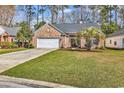 Charming brick home features a well-manicured lawn and a two-car garage, blending comfort with curb appeal at 1151 N Blackmoor Dr., Murrells Inlet, SC 29576