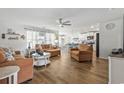 Open-concept living room with wood floors, plush seating, and bright natural light, perfect for relaxation at 140 Golden Bear Circle, Longs, SC 29568