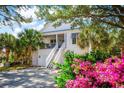 Beautiful coastal home with staircase, double garage and vibrant landscaping with pink flowers at 208 Summer Wind Loop, Murrells Inlet, SC 29576