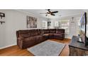 A well-lit living room features a brown sectional, hardwood floors, a ceiling fan, and a TV at 2629 Scarecrow Way, Myrtle Beach, SC 29579