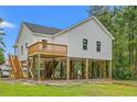Side exterior of elevated coastal home features wood decking and stairs at 3566 Steamer Trace Rd., Conway, SC 29527