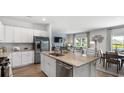 Open kitchen featuring white cabinets, stainless appliances, and a kitchen island with seating area at 358 Ladyfish Loop, Sunset Beach, NC 28468