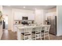 Modern kitchen featuring white cabinetry, stainless steel appliances, and a granite countertop island with seating at 362 Ladyfish Loop, Sunset Beach, NC 28468