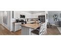 Bright modern kitchen with white cabinets, stainless steel appliances, and a granite countertop island with seating at 366 Ladyfish Loop, Sunset Beach, NC 28468
