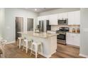 This well-lit kitchen features stainless steel appliances, granite countertops, and an island with seating at 382 Ladyfish Loop, Sunset Beach, NC 28468